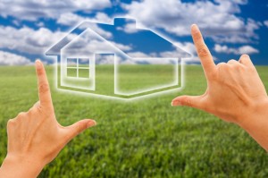 female-hands-framing-house-over-grass-and-sky